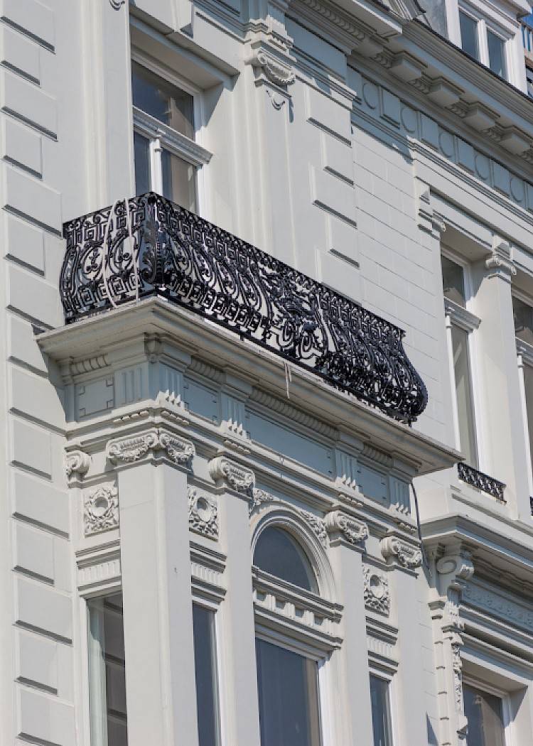 Gerenoveerde voorgevel van een herenhuis met een zwart balkon